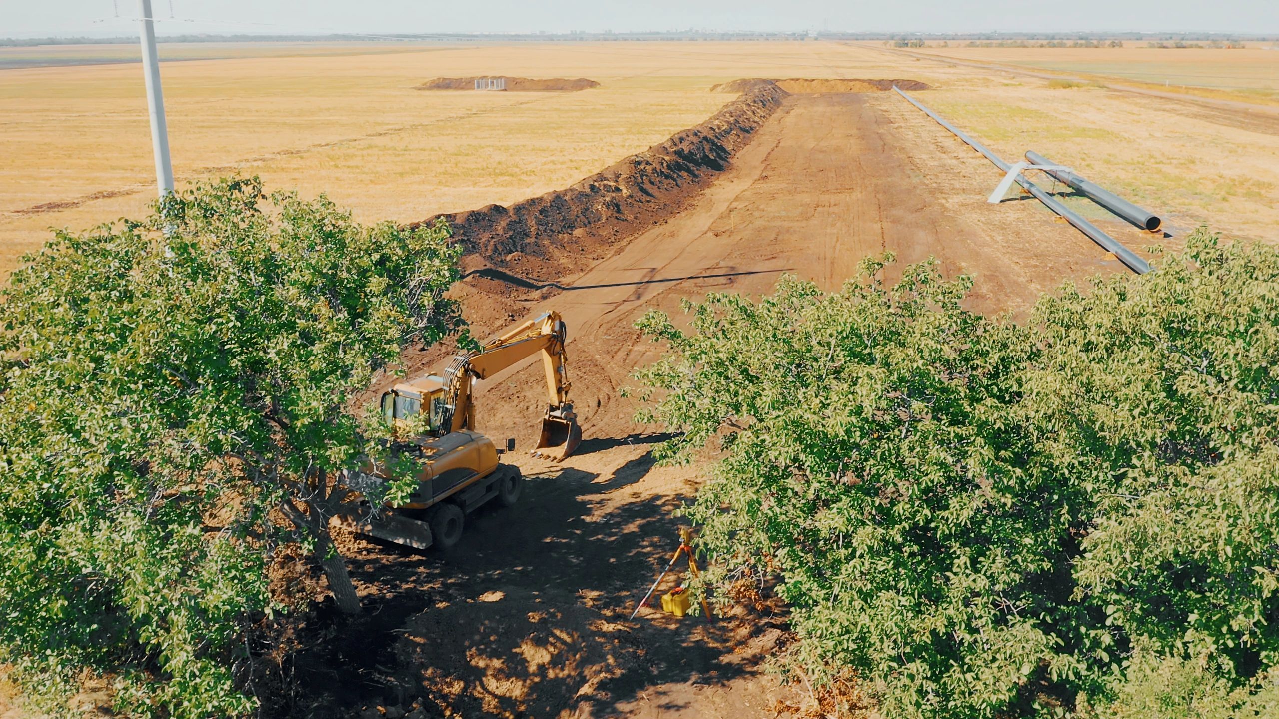 Excavator performing trenching work on a rural jobsite