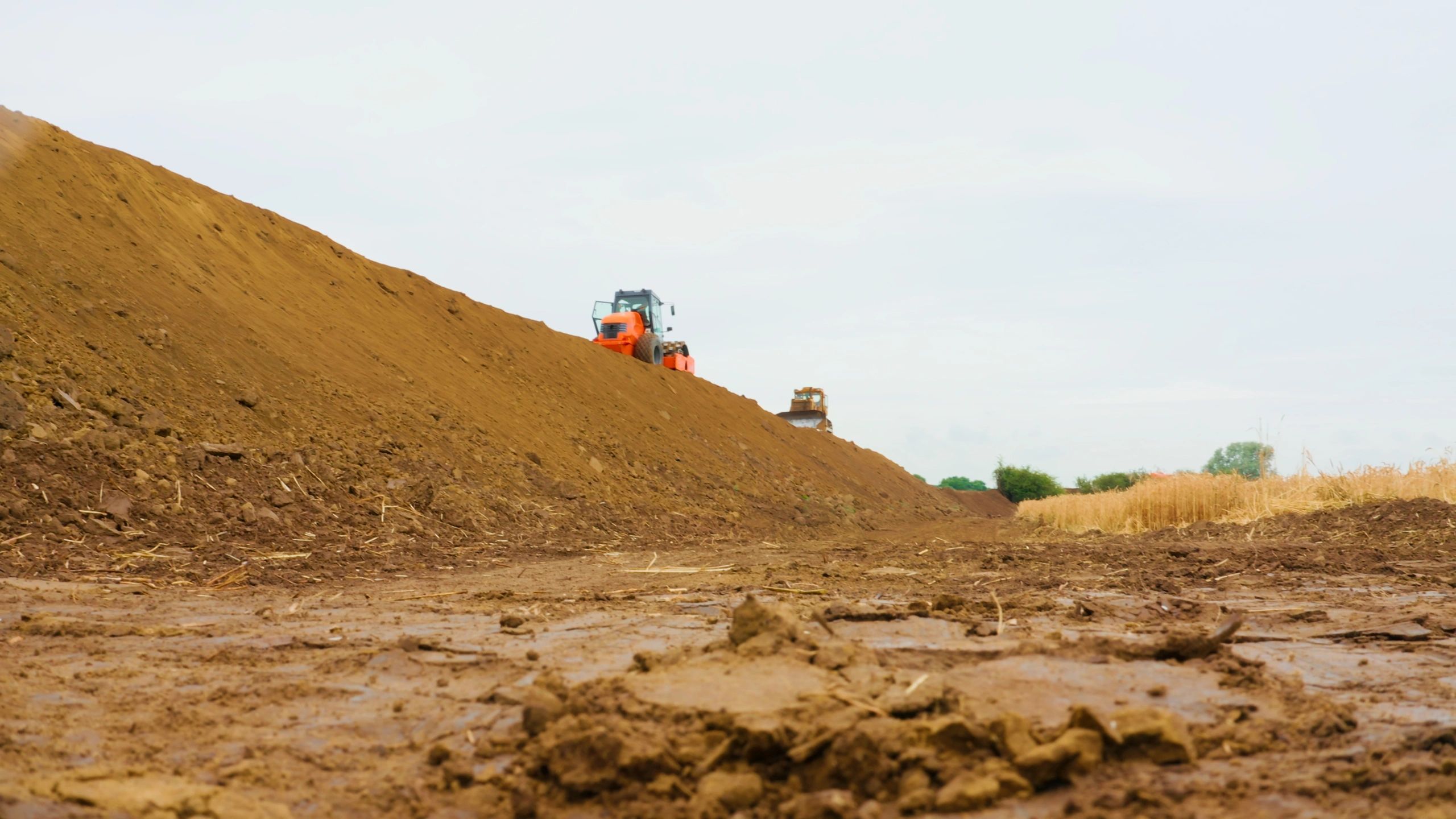 Earthmoving machinery compacting soil on a construction site