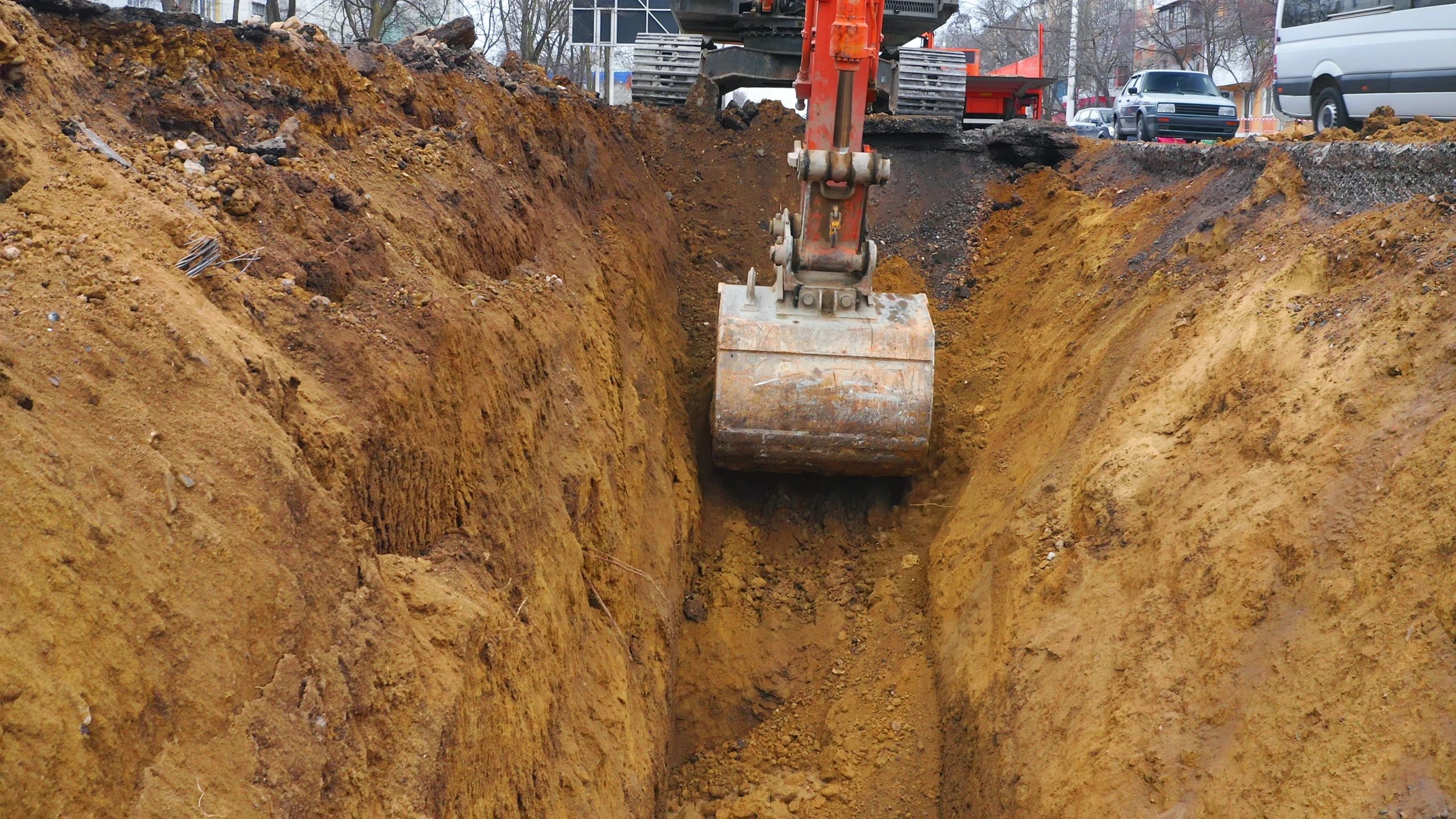 Excavator digging trench for site preparation